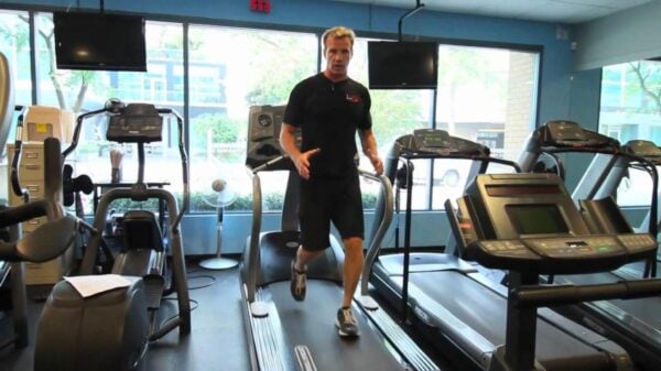 A man demonstrates how to complete a walking backwards routine on a treadmill.